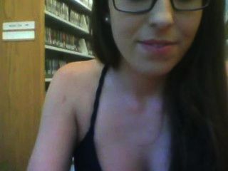 पुस्तकालय में चश्मे के साथ लड़की